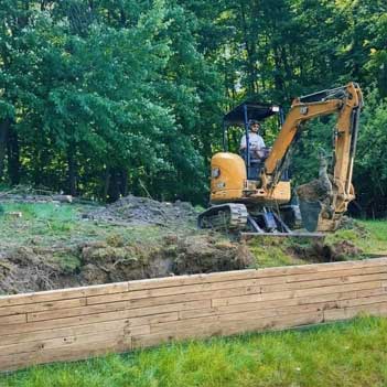 Excavating and Land Clearing - Photo of the owner of Lavish Landscaping on an excavator clearing the land for a landscaping project.