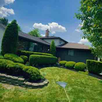 Mulching Service - A photo of a beautiful landscaped lawn and mulched gardens by Lavish Landscaping Service.
